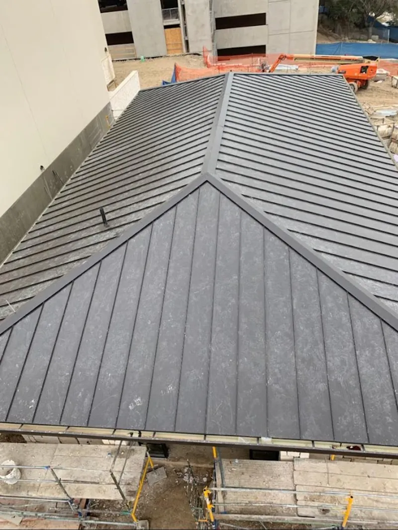 Commercial metal roof construction with crane equipment in Cedar Park